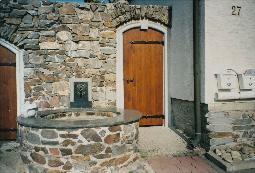 Zugangstür durch historische Natursteinmauer…